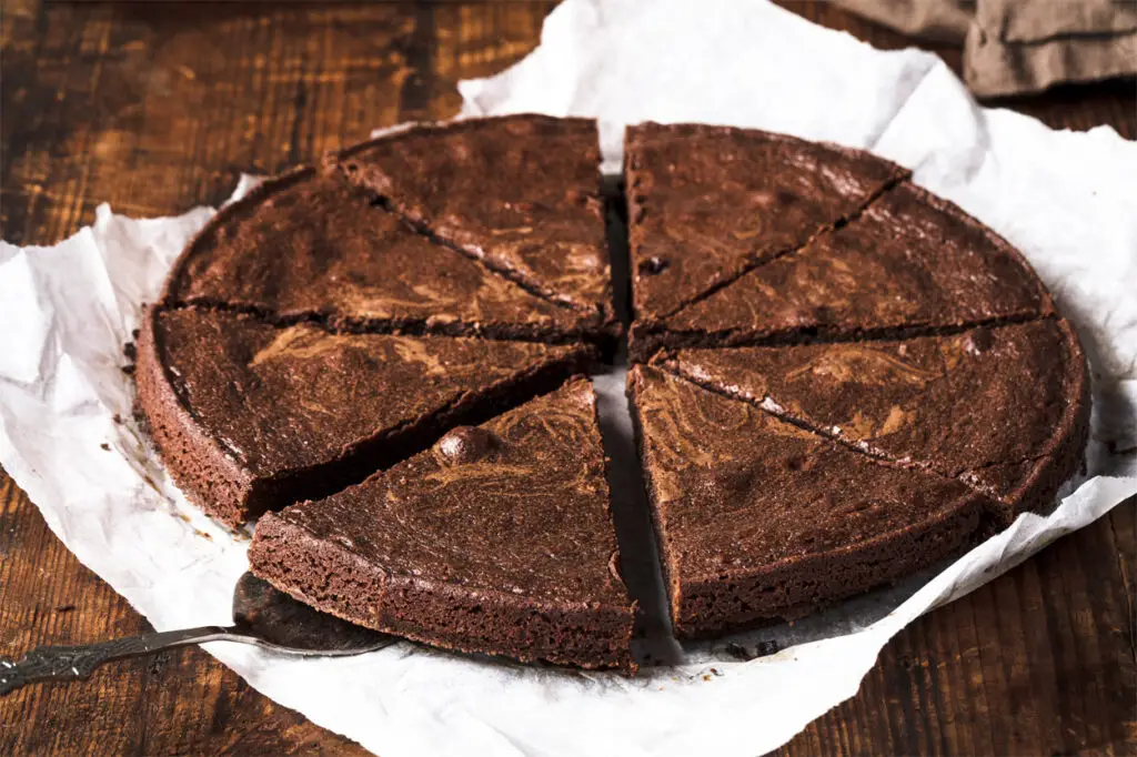Ein aufgeschnittener schwedischer Schokoladenkuchen auf Butterbrotpapier.